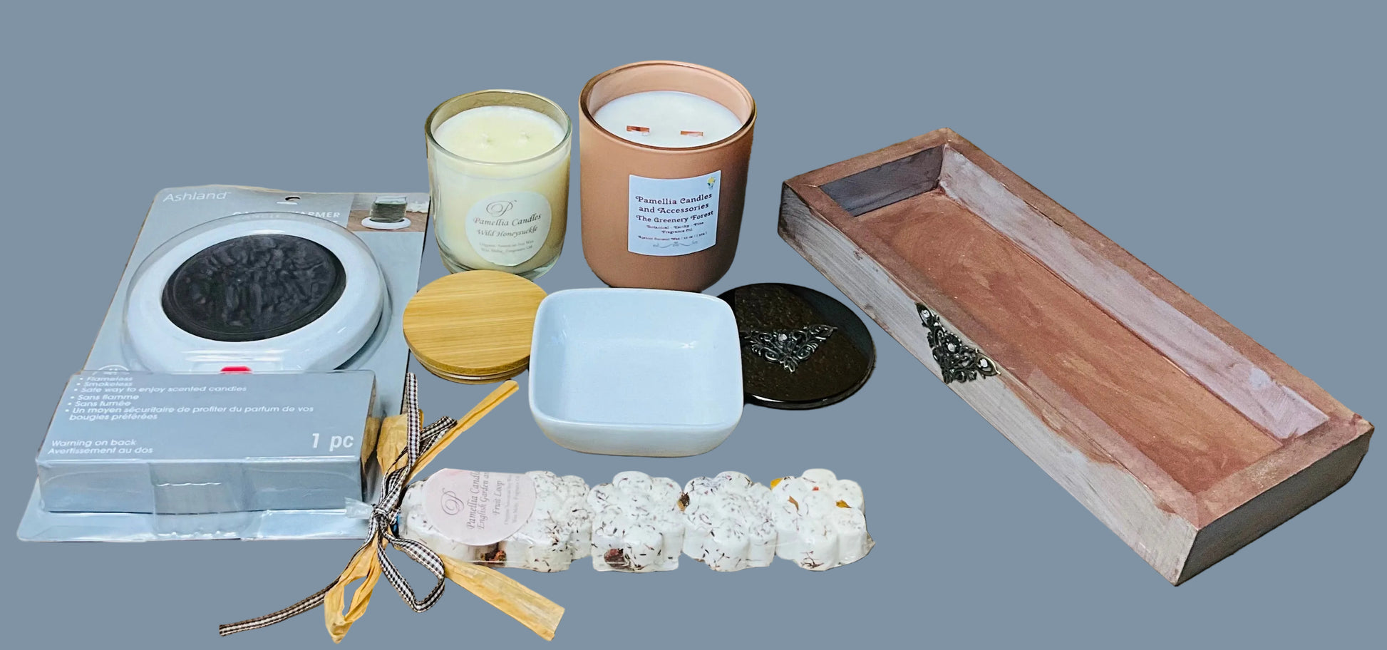 Collection of candles, a diffuser, and a wooden tray on a wooden surface with a yellow wall background.